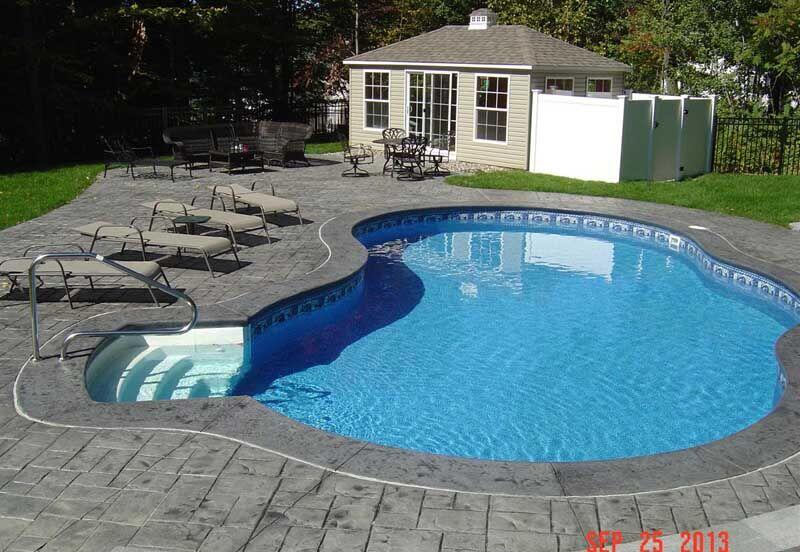 Kidney pool with stamped ashlar deck and pool house