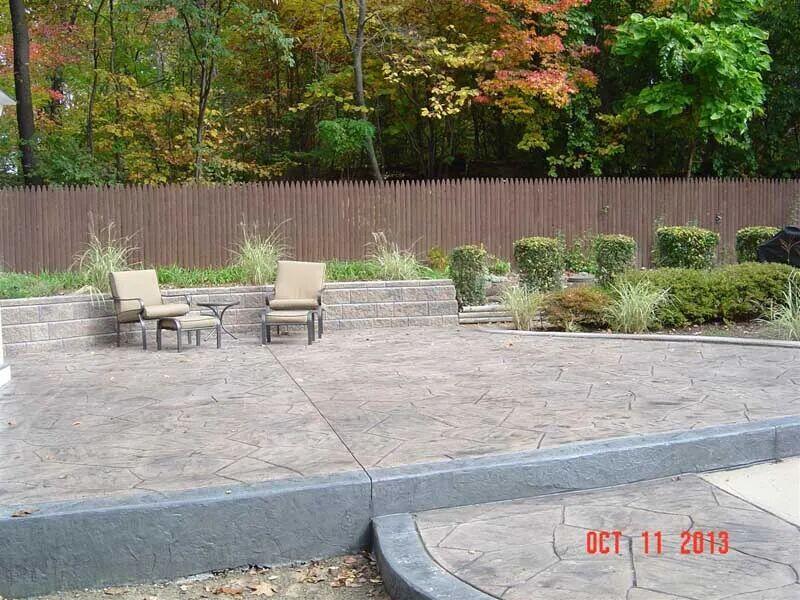 Large ashlar stamped patio with seat walls and fall foliage