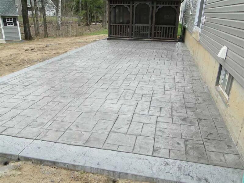 Ashlar stamped concrete patio beside gazebo