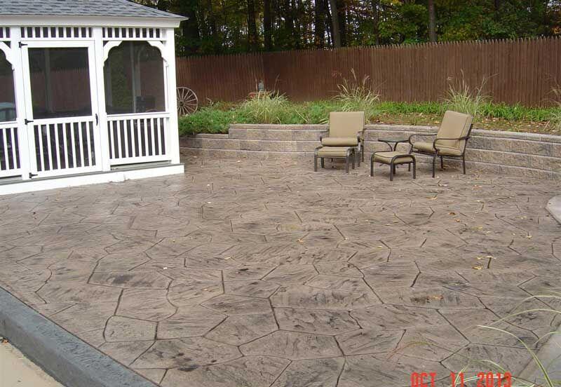 Large flagstone stamped patio with gazebo seat wall and chairs