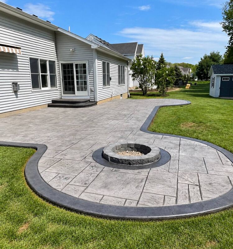Gray ashlar stamped patio charcoal border inset fire pit white siding