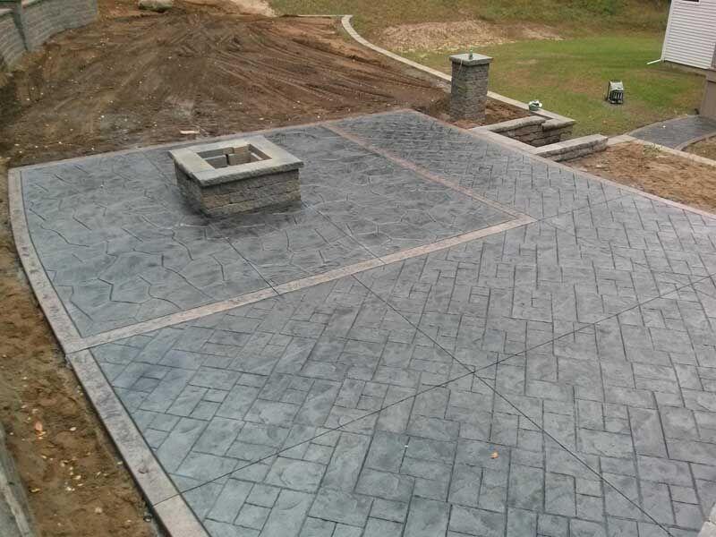 Fresh stamped patio with herringbone and flagstone fields plus block fire pit