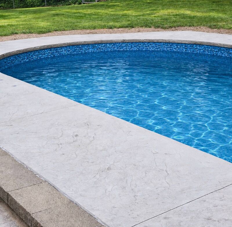 Gray stamped pool coping curved edge closeup